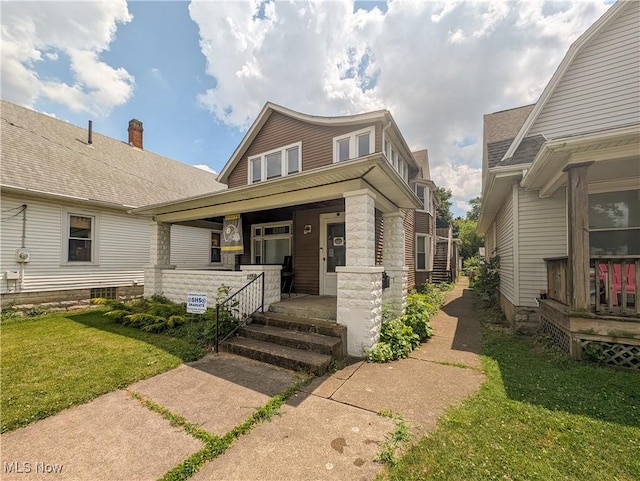 612 W Osborne St, Sandusky, OH 44870 - view of front of home featuring covered porch, a front yard, and stone siding