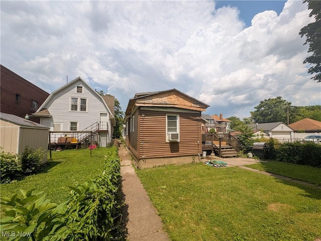 612 W Osborne St, Sandusky, OH 44870 - rear view of property with a yard, a wooden deck, cooling unit, and a storage shed