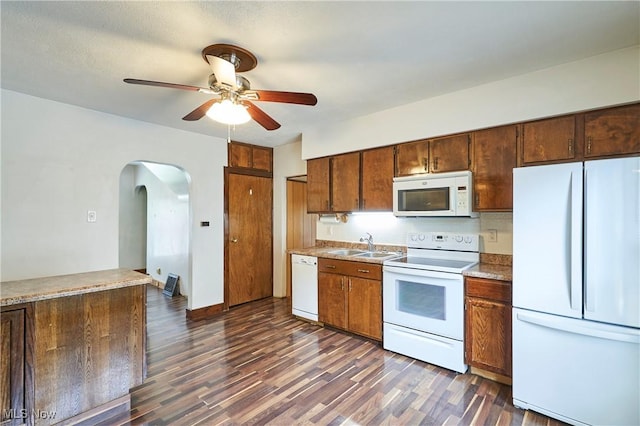 1021 Perry Ave, Barberton, OH 44203 - kitchen featuring white appliances, a ceiling fan, arched walkways, dark wood-type flooring, and light countertops