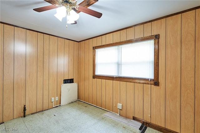 1021 Perry Ave, Barberton, OH 44203 - unfurnished room featuring light floors, wooden walls, and ceiling fan