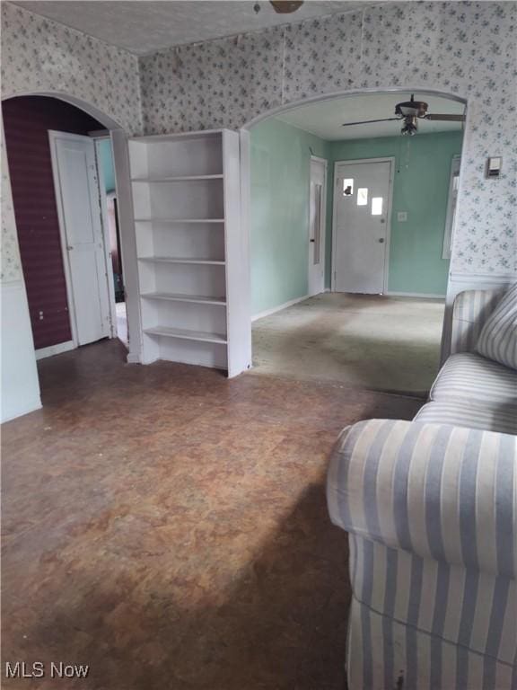 1862 15th St SW, Akron, OH 44314 - living room featuring wallpapered walls, arched walkways, and a ceiling fan