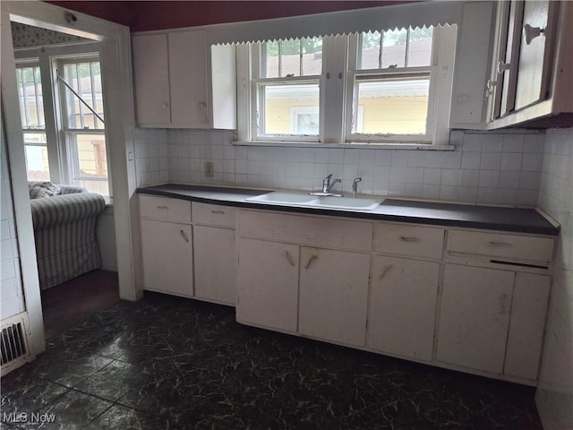 1862 15th St SW, Akron, OH 44314 - kitchen featuring healthy amount of natural light, backsplash, and white cabinetry