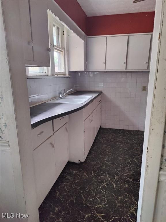 1862 15th St SW, Akron, OH 44314 - kitchen featuring white cabinetry and backsplash