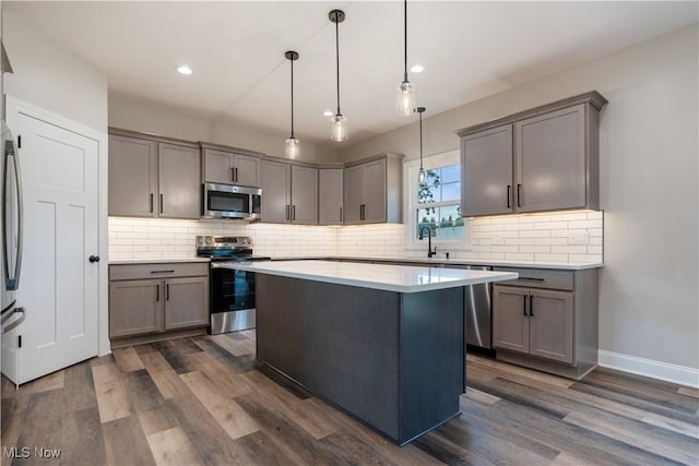 8452 Beatty St NW, Massillon, OH 44646 - kitchen with appliances with stainless steel finishes, dark wood-style flooring, a center island, decorative backsplash, and recessed lighting