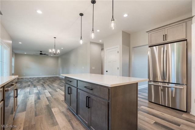 8452 Beatty St NW, Massillon, OH 44646 - kitchen featuring appliances with stainless steel finishes, wood finished floors, hanging light fixtures, recessed lighting, and light countertops