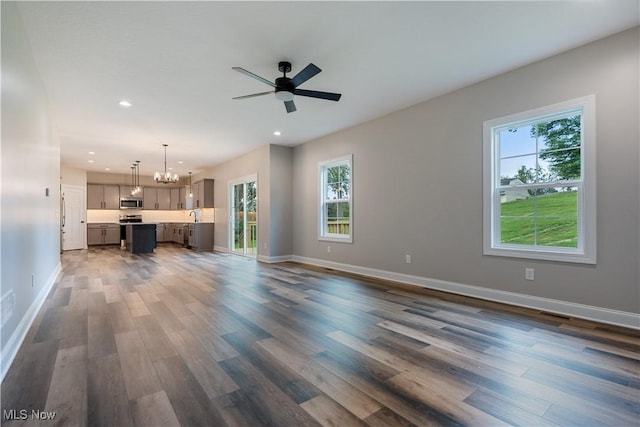 8452 Beatty St NW, Massillon, OH 44646 - unfurnished living room with plenty of natural light, dark wood-style floors, a chandelier, recessed lighting, and ceiling fan