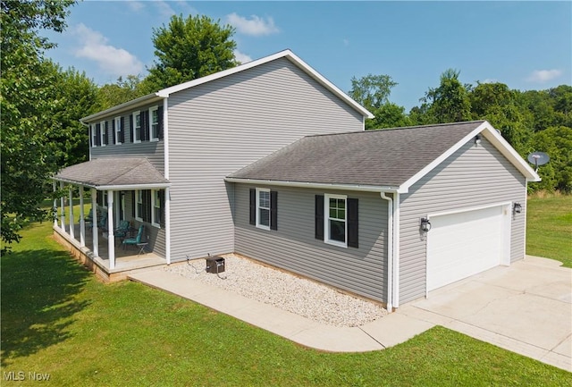 2939 Sandhill Rd, Marietta, OH 45750 - back of property featuring a lawn, driveway, an attached garage, and roof with shingles