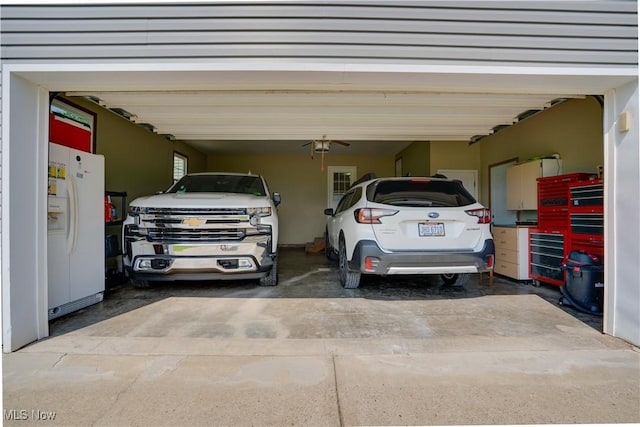 2939 Sandhill Rd, Marietta, OH 45750 - garage with white refrigerator with ice dispenser and driveway