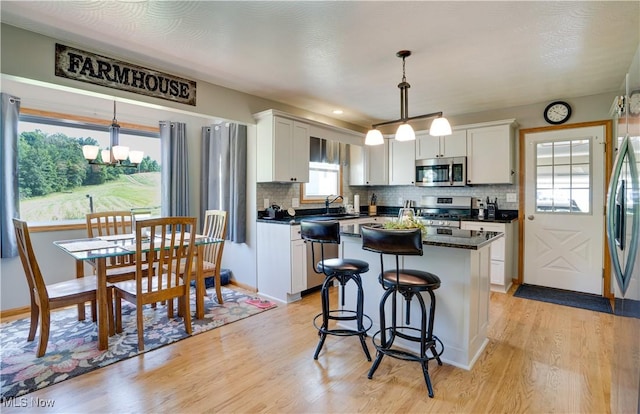 2939 Sandhill Rd, Marietta, OH 45750 - kitchen with stainless steel appliances, dark countertops, light wood-style flooring, and backsplash