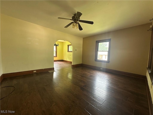1012 Chandler Ave, Akron, OH 44314 - spare room with healthy amount of natural light, arched walkways, a ceiling fan, and dark wood-type flooring