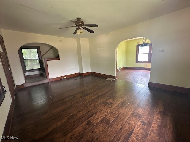 1012 Chandler Ave, Akron, OH 44314 - empty room featuring arched walkways, dark wood-style flooring, and a ceiling fan