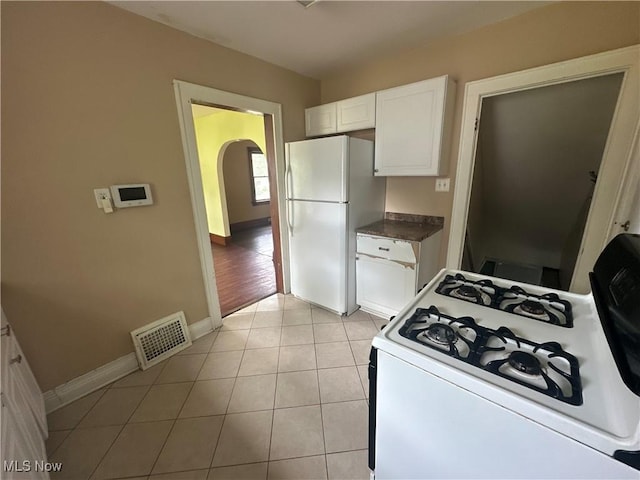 1012 Chandler Ave, Akron, OH 44314 - kitchen with white appliances, white cabinetry, dark countertops, and light tile patterned floors