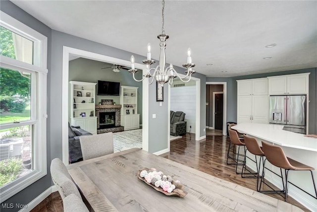 18367 Cranberry Ridge Ln, Chagrin Falls, OH 44023 - dining space featuring a chandelier, a stone fireplace, wood finished floors, and a ceiling fan