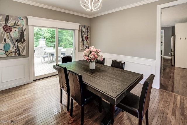 18367 Cranberry Ridge Ln, Chagrin Falls, OH 44023 - dining area with light wood-style flooring, a chandelier, wainscoting, ornamental molding, and a decorative wall