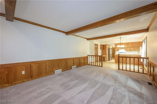 5835 Garth Cir NW, Canton, OH 44718 - spare room with a chandelier, wainscoting, light carpet, beam ceiling, and wooden walls