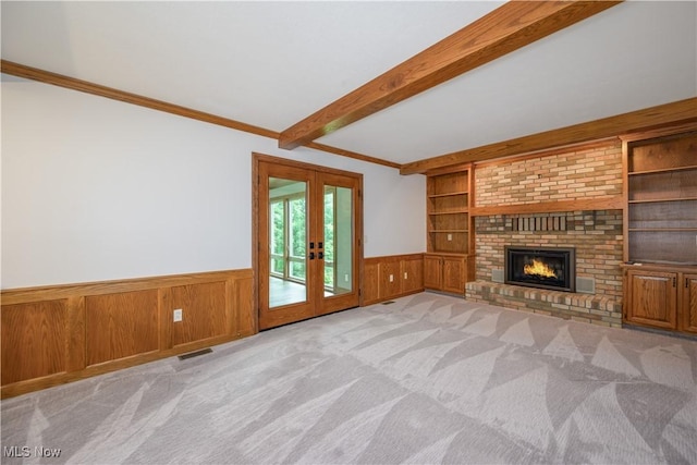 5835 Garth Cir NW, Canton, OH 44718 - unfurnished living room featuring a wainscoted wall, french doors, built in shelves, beam ceiling, and carpet floors