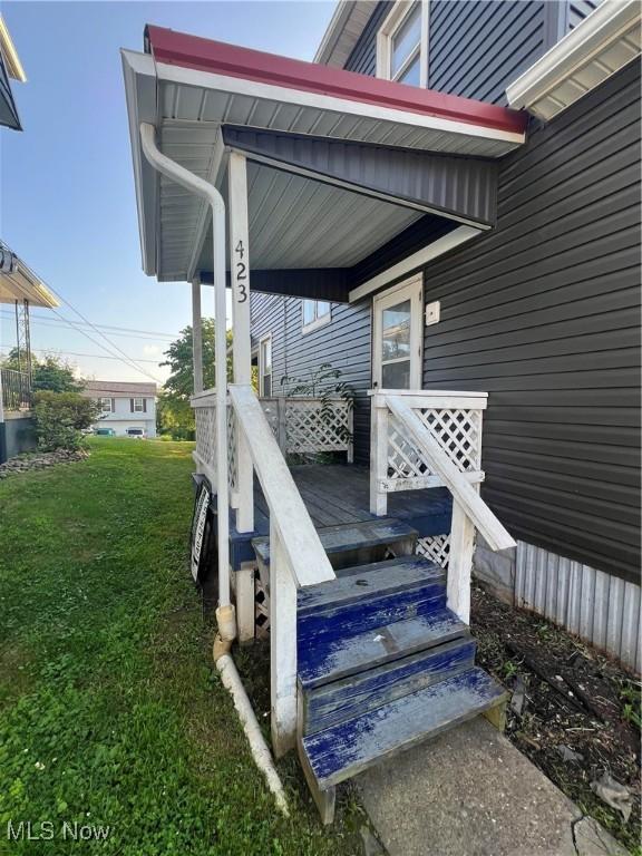 423 W Main St, Barnesville, OH 43713 - wooden porch featuring a yard