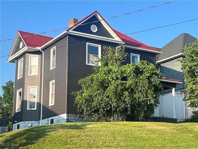 423 W Main St, Barnesville, OH 43713 - view of property exterior with a lawn, a chimney, and a metal roof