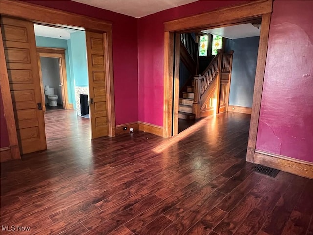 423 W Main St, Barnesville, OH 43713 - spare room featuring wood finished floors, stairs, and a fireplace