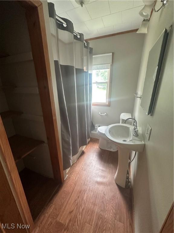 600 Jeanette Ave, Martins Ferry, OH 43935 - bathroom featuring a shower with curtain, wood finished floors, and ornamental molding