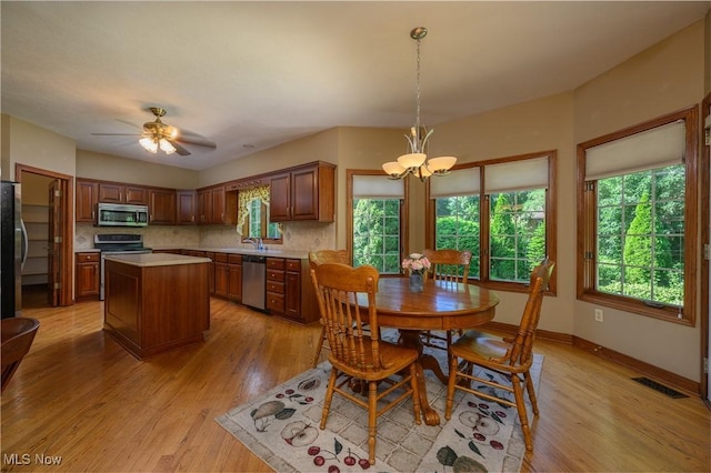 1110 Mansion Dr, Barberton, OH 44203 - dining space with light wood-style floors, a chandelier, and a ceiling fan