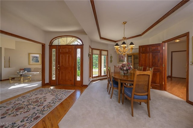 1110 Mansion Dr, Barberton, OH 44203 - dining space featuring a chandelier, wood finished floors, a tray ceiling, and ornamental molding