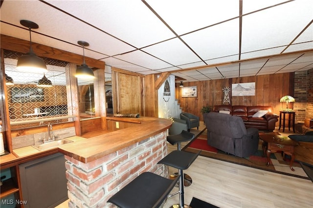 27 Robinson Ln, Weirton, WV 26062 - indoor wet bar featuring wood walls, light wood-style flooring, hanging light fixtures, and a drop ceiling
