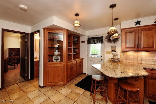 27 Robinson Ln, Weirton, WV 26062 - kitchen featuring a peninsula, a breakfast bar area, brown cabinetry, backsplash, and decorative light fixtures