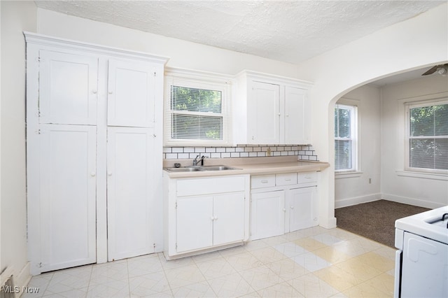 1333 Meriline St, Cuyahoga Falls, OH 44221 - kitchen featuring white cabinets, light countertops, healthy amount of natural light, arched walkways, and a textured ceiling