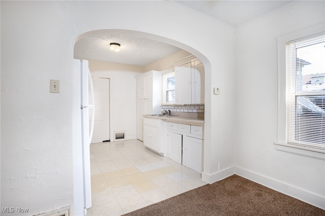 1333 Meriline St, Cuyahoga Falls, OH 44221 - kitchen featuring freestanding refrigerator, arched walkways, white cabinets, and light countertops