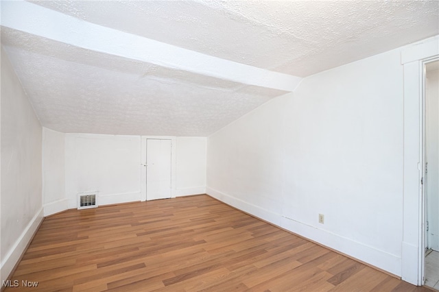 1333 Meriline St, Cuyahoga Falls, OH 44221 - additional living space featuring wood finished floors, a textured ceiling, and vaulted ceiling