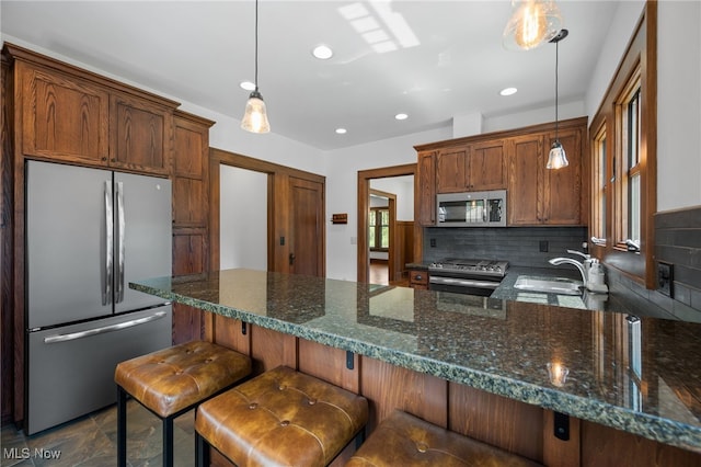 159 Edgerton Rd, Akron, OH 44303 - kitchen featuring appliances with stainless steel finishes, decorative backsplash, recessed lighting, hanging light fixtures, and dark stone countertops