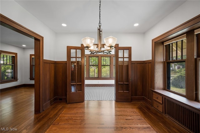 159 Edgerton Rd, Akron, OH 44303 - unfurnished dining area featuring dark wood-type flooring, a chandelier, wainscoting, wooden walls, and radiator heating unit