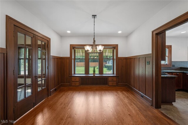 159 Edgerton Rd, Akron, OH 44303 - unfurnished dining area featuring radiator, wainscoting, french doors, a chandelier, and wood finished floors