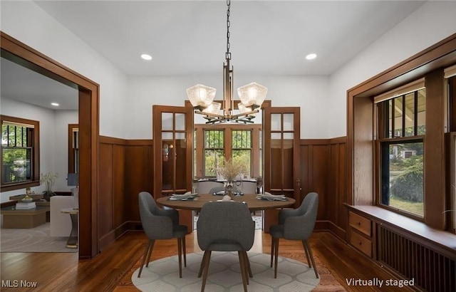 159 Edgerton Rd, Akron, OH 44303 - dining area featuring wainscoting, dark wood-type flooring, a chandelier, wooden walls, and radiator heating unit