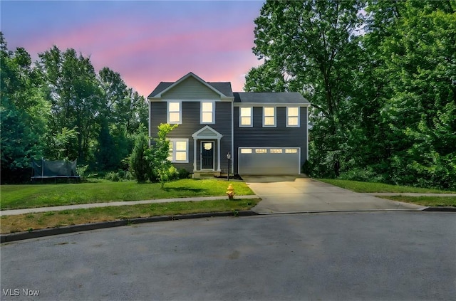 301 Karson Dr, Akron, OH 44312 - view of front facade featuring a trampoline, driveway, a garage, and a front yard