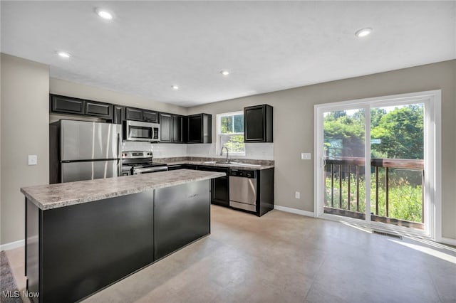 301 Karson Dr, Akron, OH 44312 - kitchen featuring stainless steel appliances, a kitchen island, recessed lighting, dark cabinetry, and finished concrete flooring