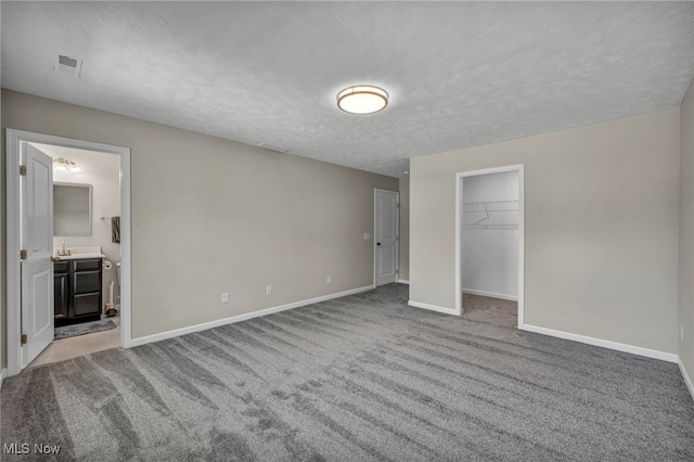 301 Karson Dr, Akron, OH 44312 - unfurnished bedroom with carpet, a textured ceiling, a walk in closet, and ensuite bath