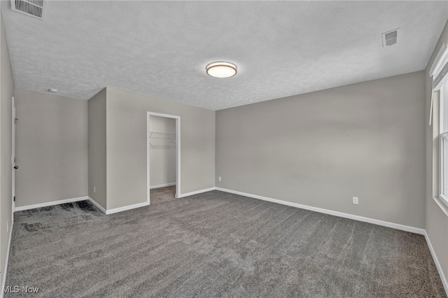 301 Karson Dr, Akron, OH 44312 - unfurnished bedroom featuring a textured ceiling, carpet flooring, and a walk in closet