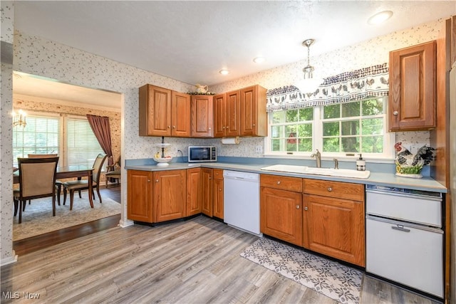 3043 E Wallings Rd, Broadview Heights, OH 44147 - kitchen with dishwasher, wallpapered walls, light wood finished floors, and brown cabinetry