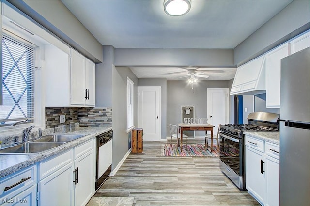 1648 Frederick Ave SW, Canton, OH 44706 - kitchen with stainless steel appliances, white cabinets, light wood-type flooring, a ceiling fan, and light countertops