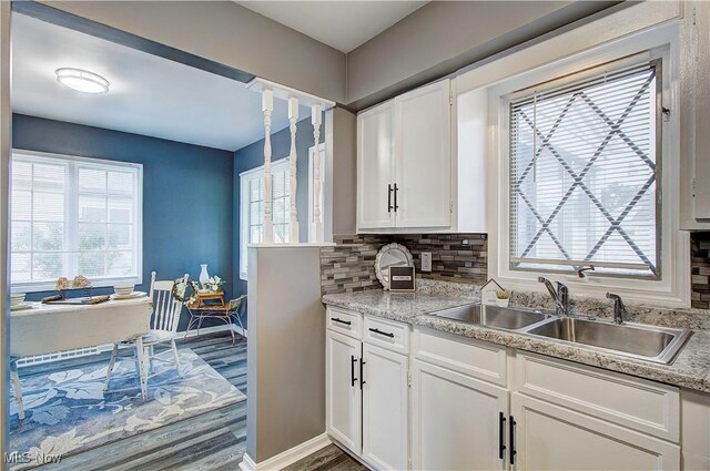 1648 Frederick Ave SW, Canton, OH 44706 - kitchen with white cabinets, tasteful backsplash, healthy amount of natural light, and light countertops