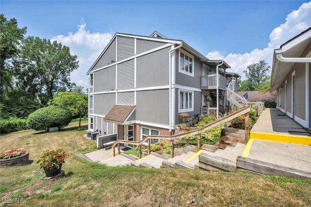 255 Portage Lakes Dr Unit E, Akron, OH 44319 - back of house featuring a lawn, a patio, stairs, and brick siding