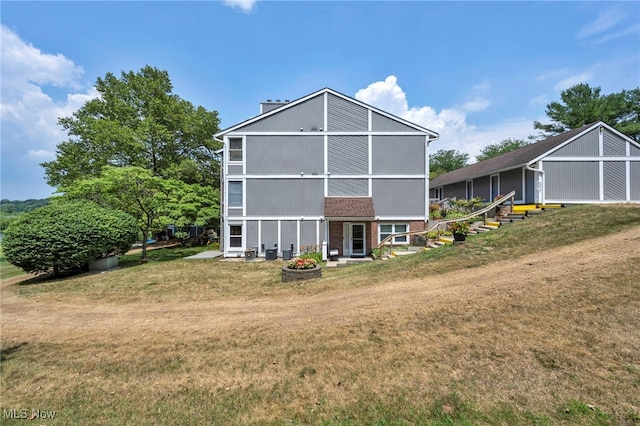 255 Portage Lakes Dr Unit E, Akron, OH 44319 - back of property featuring a lawn and brick siding