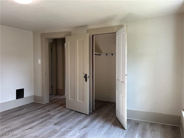 26 E Satin St, Jefferson, OH 44047 - unfurnished bedroom featuring a closet and light wood-type flooring