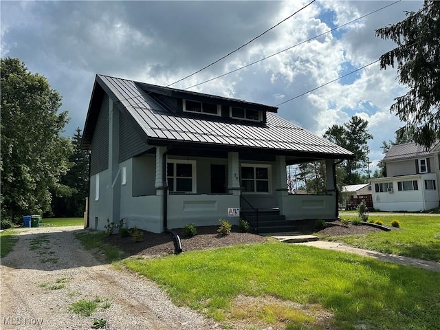 26 E Satin St, Jefferson, OH 44047 - view of front facade with a standing seam roof, covered porch, driveway, a metal roof, and a front yard