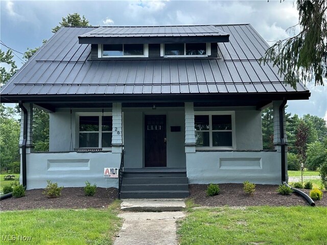 26 E Satin St, Jefferson, OH 44047 - view of front facade featuring a standing seam roof, a porch, and stucco siding