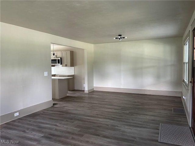 26 E Satin St, Jefferson, OH 44047 - unfurnished living room with baseboards and dark wood-style floors
