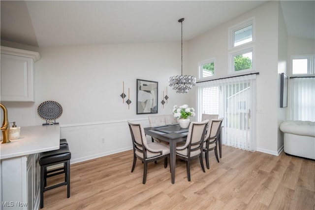 117 Nicklaus Dr NE, Warren, OH 44484 - dining area featuring light wood-style flooring, a chandelier, and high vaulted ceiling