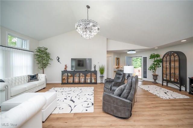 117 Nicklaus Dr NE, Warren, OH 44484 - living room with a chandelier, plenty of natural light, wood finished floors, and high vaulted ceiling